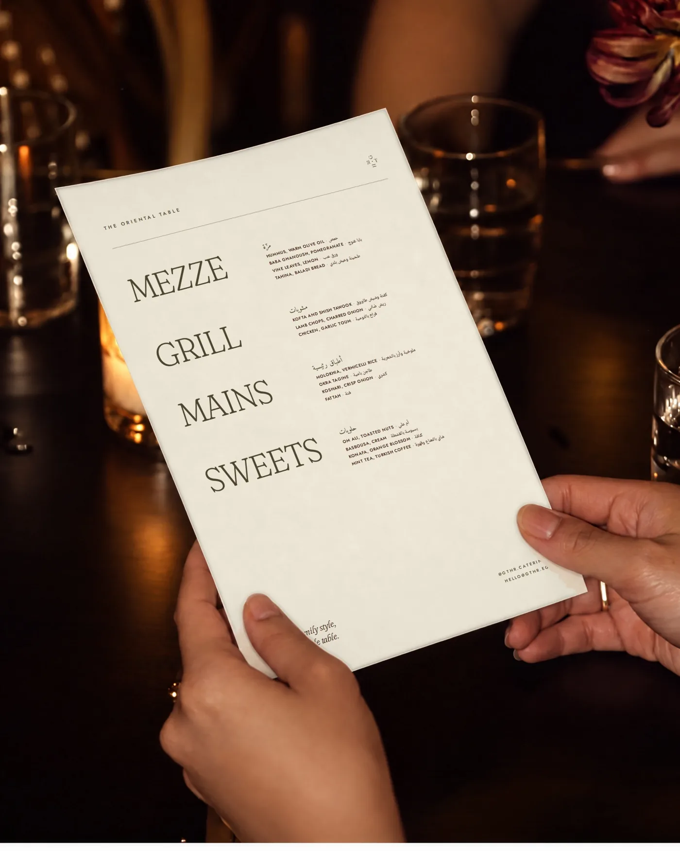 Hands holding the GTHR menu at dinner